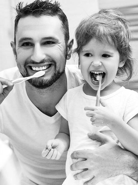 Vater mit Tochter beim Zähneputzen